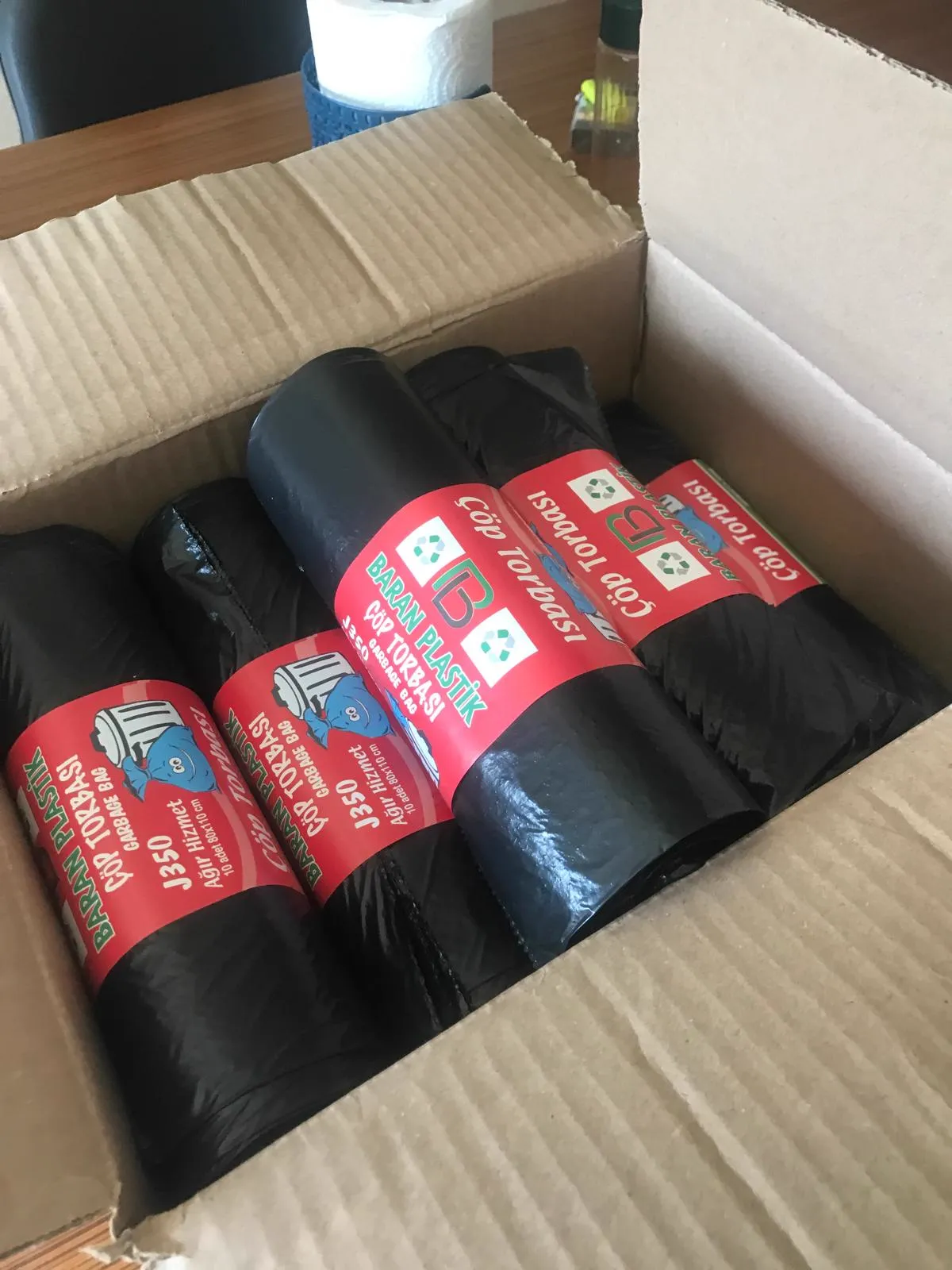 Black garbage bag rolls packed in cardboard box
