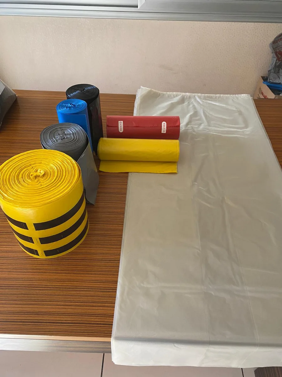 Bin liner rolls and large clear polythene bag on a table
